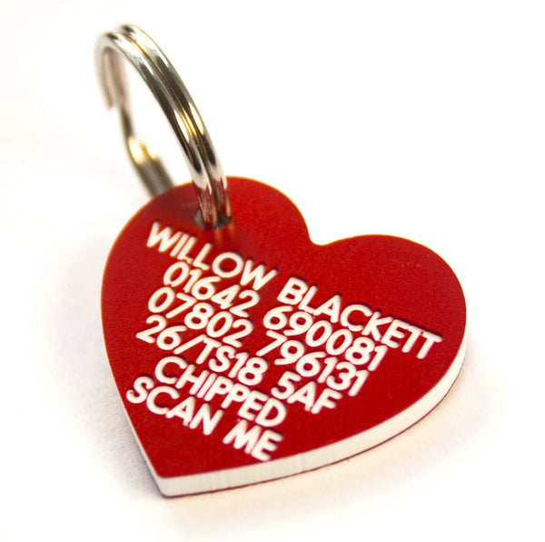 Red heart-shaped pet ID tag with engraved owner information and phone number