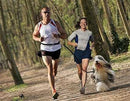 Couple jogging with dog using shock-absorbing reflective dog jogging lead with adjustable length and neoprene padded grip