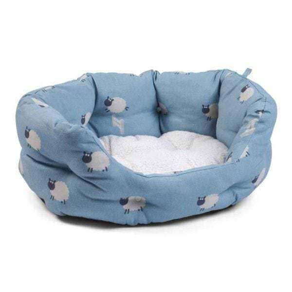 Blue oval dog bed with sheep pattern, high sides, and reversible inner cushion for comfort.