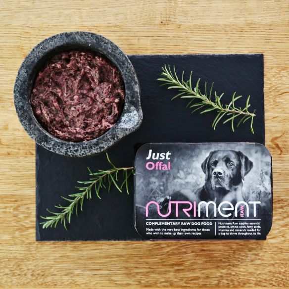 Nutriment Just Offal Raw Dog Food 500g Tray with green beef tripe, beef heart, liver, and kidney, shown in a stone bowl and packaging, on wooden surface.