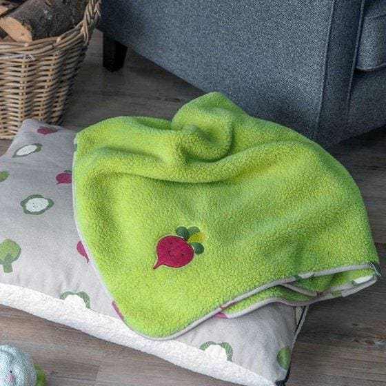 Veggie Patch Dog Comforter Blanket with green sherpa fabric and faux fur, shown on a patterned pillow.
